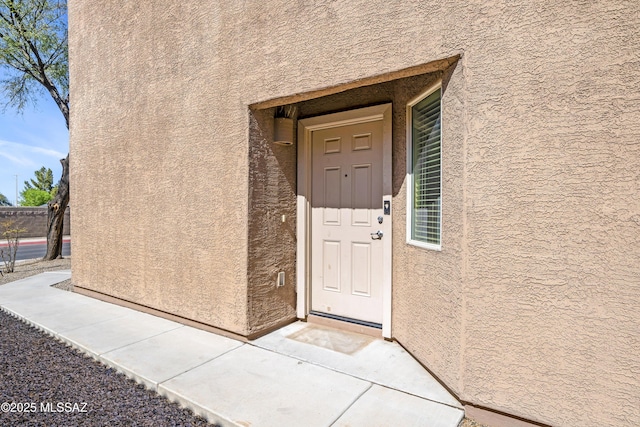 doorway to property featuring stucco siding