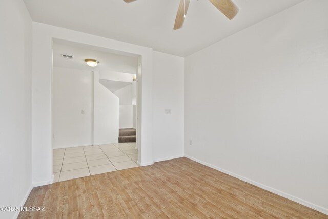 unfurnished room featuring baseboards, visible vents, ceiling fan, and wood finished floors