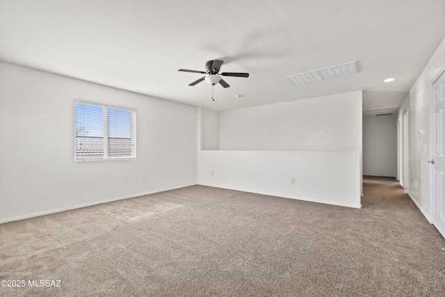 carpeted empty room with baseboards, visible vents, and ceiling fan