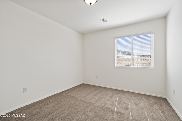 empty room with baseboards, carpet flooring, and visible vents