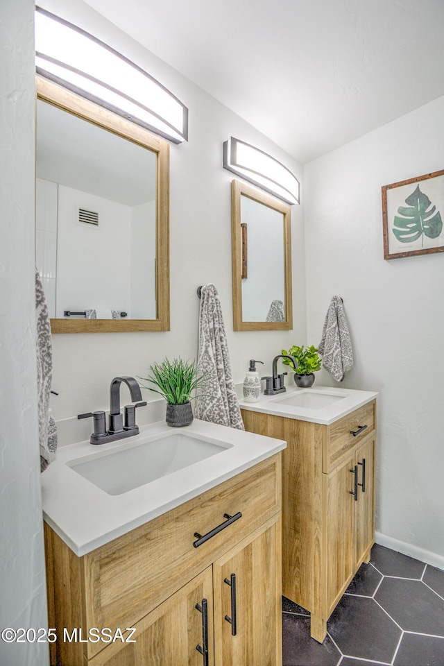 bathroom with two vanities, tile patterned flooring, visible vents, and a sink