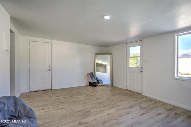 foyer entrance with light wood finished floors and baseboards