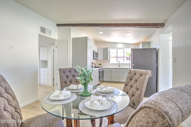 dining area featuring light wood-type flooring, visible vents, beamed ceiling, and recessed lighting