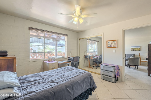 bedroom with light tile patterned floors, a ceiling fan, and a closet