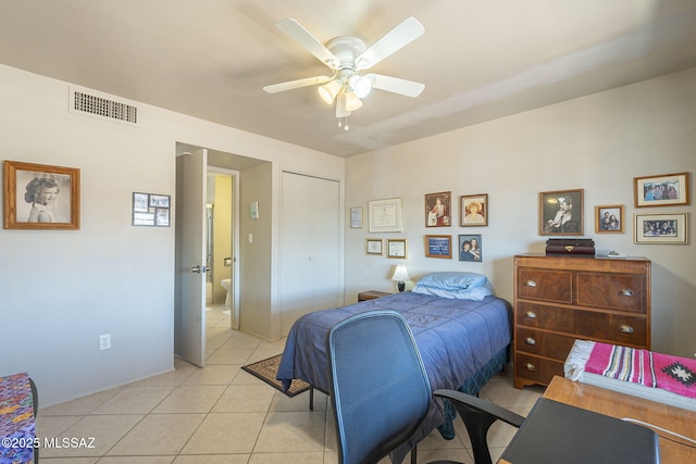 bedroom with light tile patterned floors, visible vents, a closet, and a ceiling fan