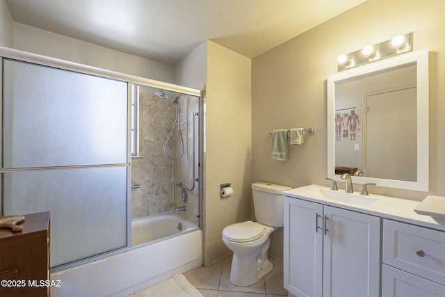 bathroom featuring enclosed tub / shower combo, toilet, vanity, and tile patterned flooring