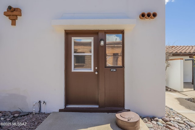 entrance to property featuring stucco siding