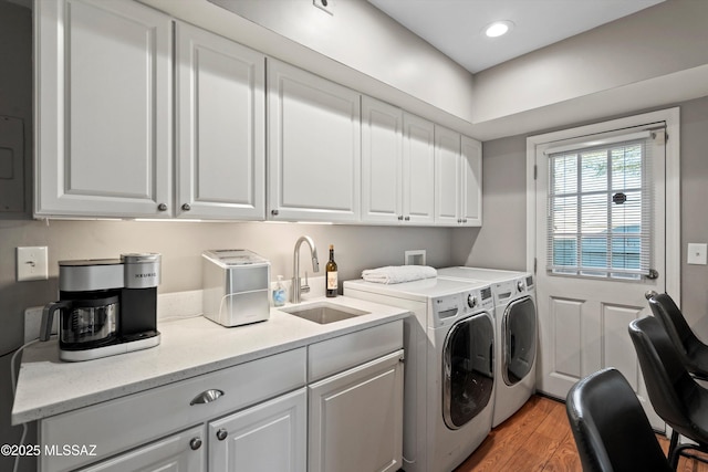 washroom featuring light wood-type flooring, a sink, recessed lighting, cabinet space, and separate washer and dryer