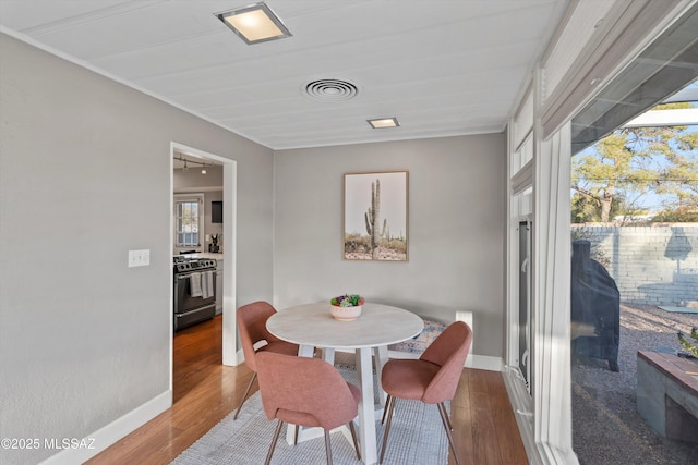 dining area featuring wood finished floors, visible vents, and a wealth of natural light