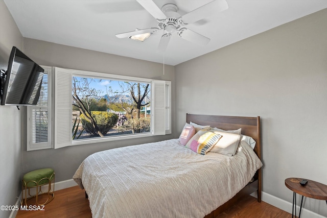 bedroom featuring wood finished floors, baseboards, and ceiling fan