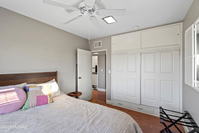 bedroom featuring a closet, visible vents, a ceiling fan, and wood finished floors