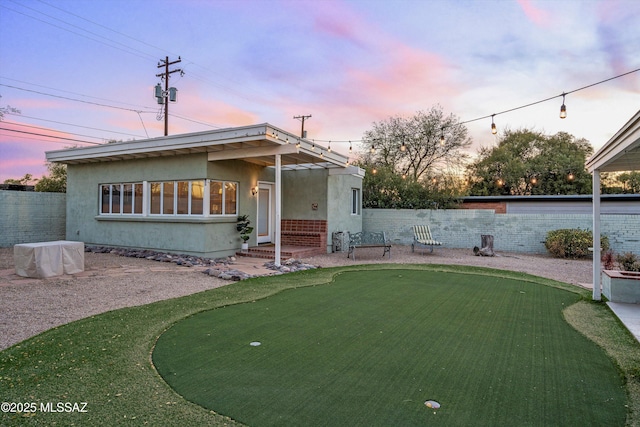 view of front facade with stucco siding, entry steps, and fence