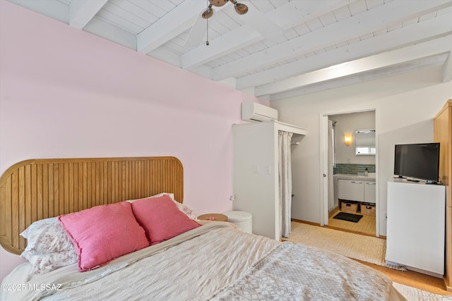 bedroom with an AC wall unit, ensuite bathroom, and beam ceiling