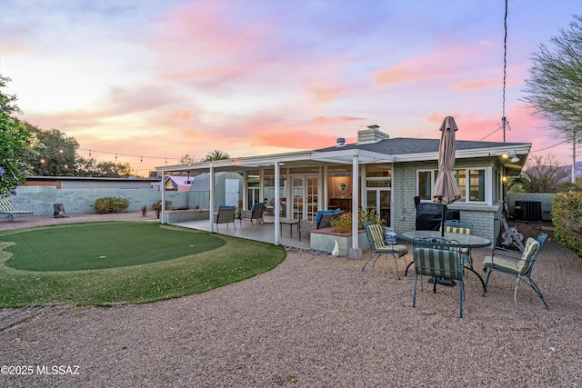 rear view of property with a patio, fence, central AC unit, and brick siding