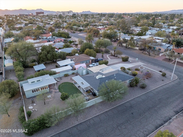 aerial view at dusk featuring a mountain view and a residential view