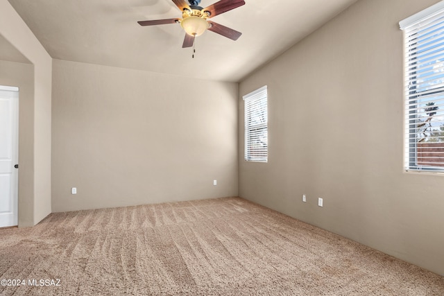 carpeted spare room featuring ceiling fan