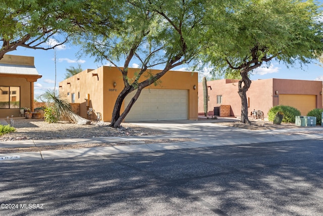 southwest-style home with stucco siding, concrete driveway, and an attached garage