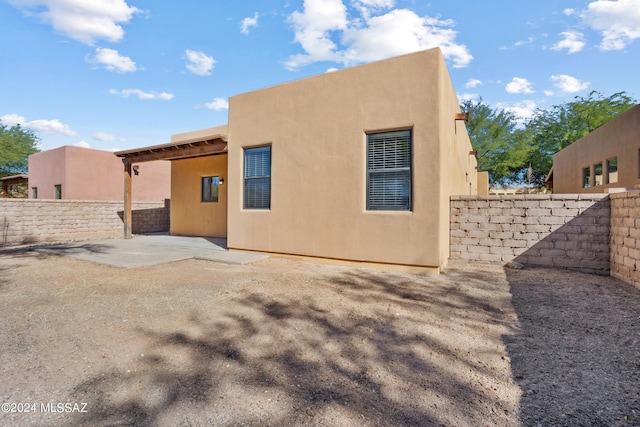 rear view of property with a patio, a fenced backyard, and stucco siding