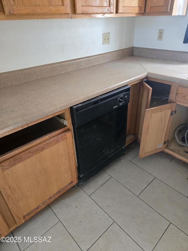 kitchen featuring black dishwasher, light tile patterned flooring, and light countertops