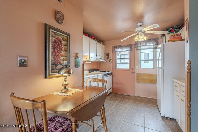 dining space featuring light tile patterned floors and a ceiling fan