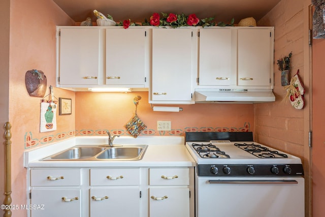 kitchen with under cabinet range hood, white cabinetry, a sink, and gas range gas stove