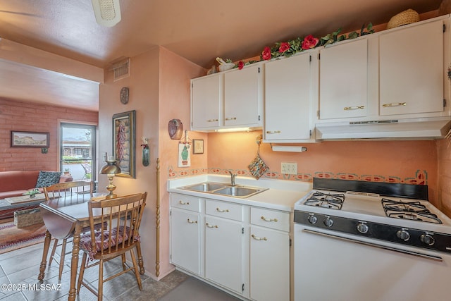 kitchen featuring white gas stove, visible vents, under cabinet range hood, light countertops, and a sink
