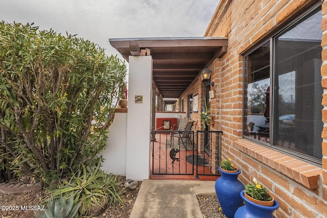 property entrance featuring brick siding and a gate