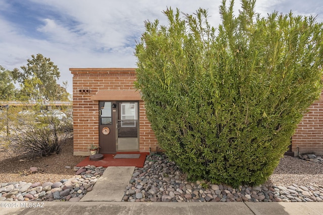 doorway to property featuring brick siding