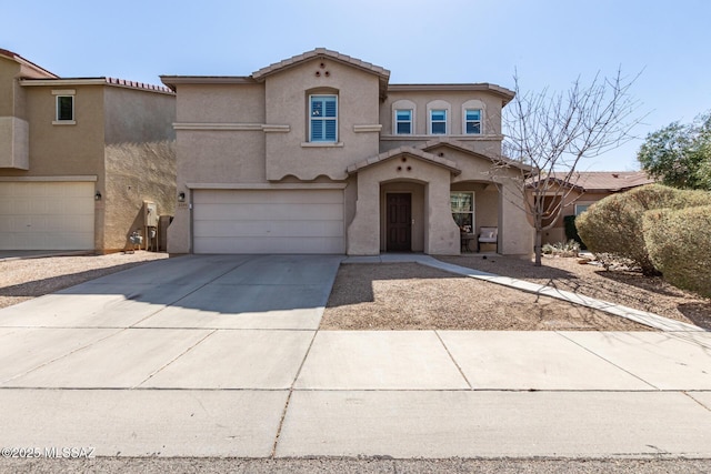 mediterranean / spanish home with stucco siding, driveway, a tile roof, and a garage