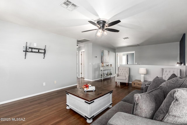 living area with visible vents, baseboards, attic access, and dark wood finished floors