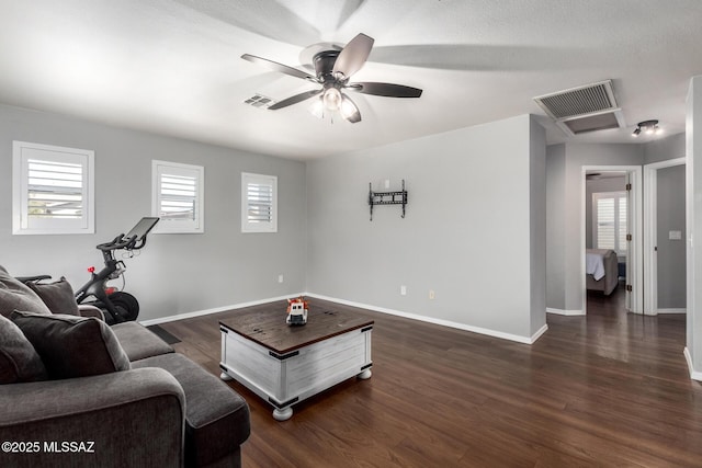 living room with visible vents, a ceiling fan, dark wood-type flooring, and baseboards