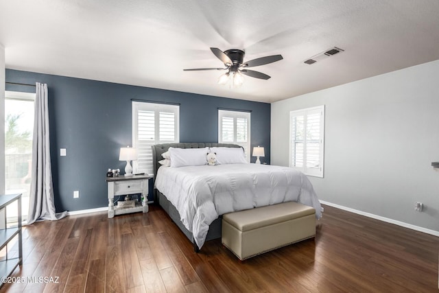 bedroom with dark wood finished floors, visible vents, baseboards, and ceiling fan