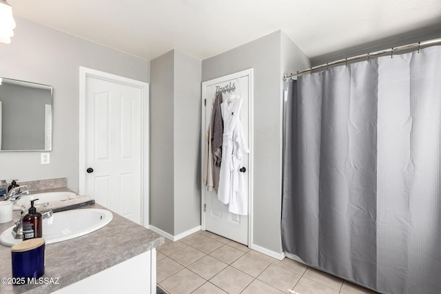 full bath with vanity, tile patterned floors, and baseboards