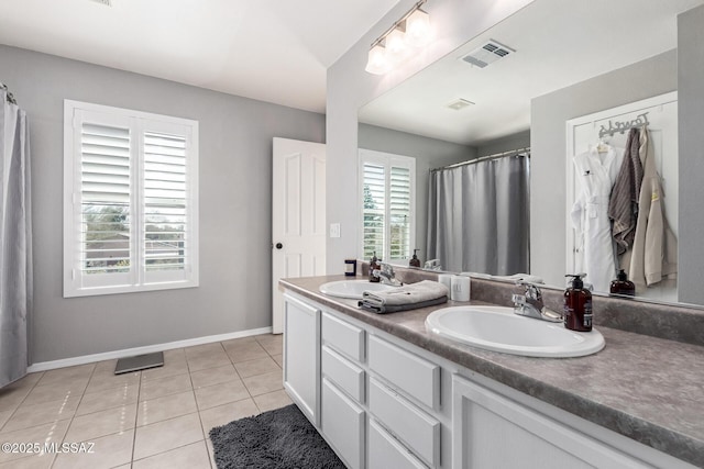 full bath featuring a sink, visible vents, double vanity, and tile patterned flooring