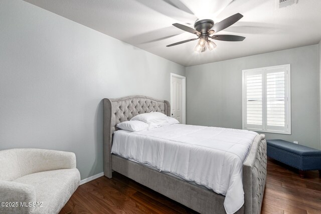 bedroom featuring visible vents, baseboards, dark wood finished floors, and a ceiling fan