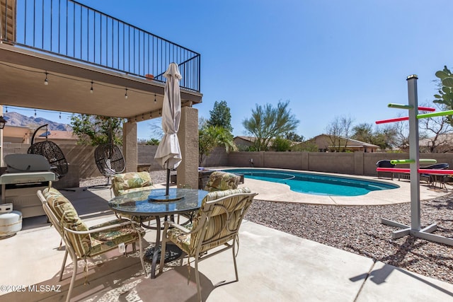 view of pool with a fenced in pool, outdoor dining area, a fenced backyard, a patio area, and area for grilling