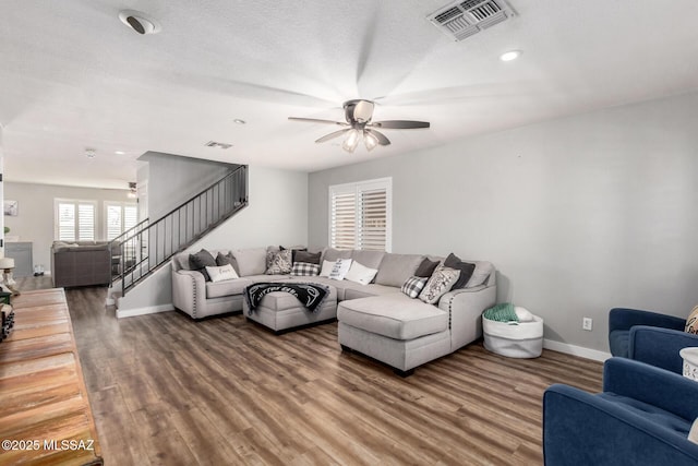 living area featuring stairway, wood finished floors, visible vents, and baseboards