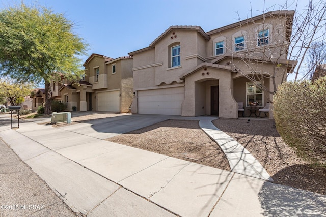 mediterranean / spanish house featuring stucco siding, a garage, driveway, and a tiled roof