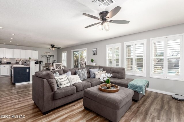 living room with visible vents, a ceiling fan, dark wood-style floors, recessed lighting, and baseboards