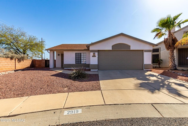 ranch-style home with stucco siding, driveway, an attached garage, and fence