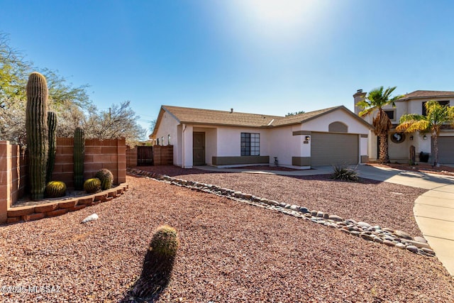 ranch-style house with concrete driveway, an attached garage, fence, and stucco siding