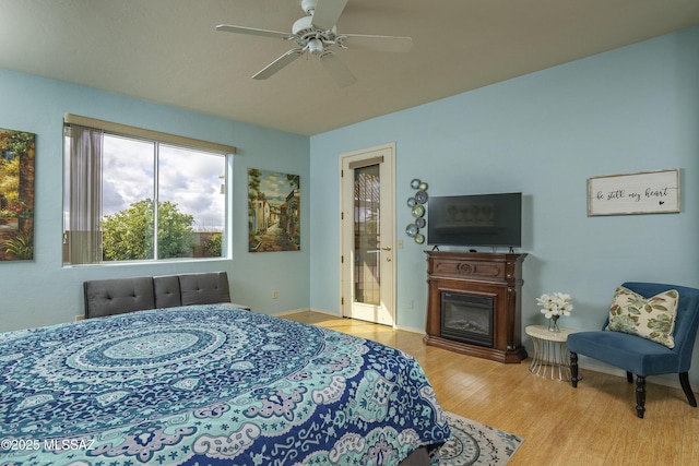 11219 N Platte Dr, Oro Valley, AZ 85737 - bedroom with a glass covered fireplace, wood finished floors, and a ceiling fan