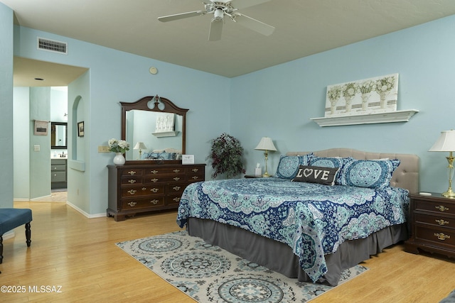 11219 N Platte Dr, Oro Valley, AZ 85737 - bedroom with visible vents, wood finished floors, arched walkways, baseboards, and ceiling fan