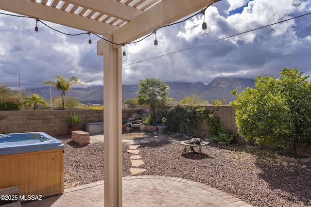 11219 N Platte Dr, Oro Valley, AZ 85737 - view of patio / terrace featuring a fenced backyard, a mountain view, a hot tub, and an outdoor fire pit