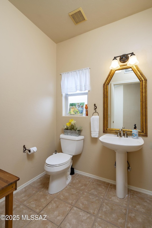 11219 N Platte Dr, Oro Valley, AZ 85737 - half bathroom featuring visible vents, toilet, baseboards, and a sink