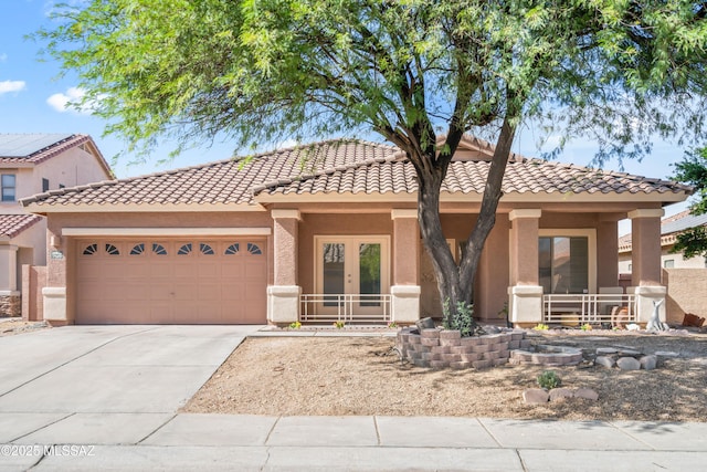 view of front facade featuring a porch, stucco siding, concrete driveway, french doors, and a garage