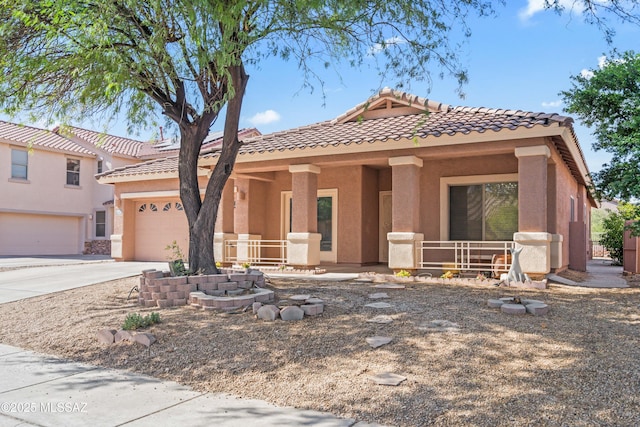 view of front of home with a tiled roof, a porch, concrete driveway, stucco siding, and an attached garage