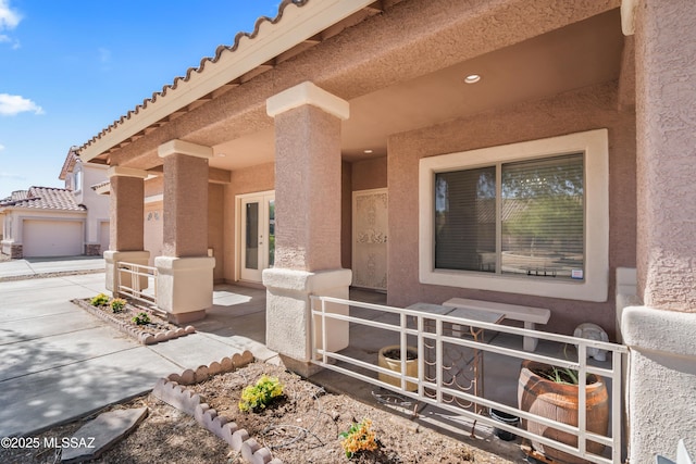 property entrance with a tiled roof, french doors, and stucco siding