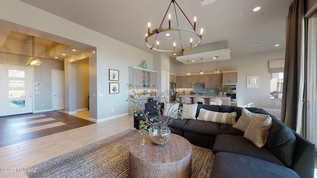 living room featuring recessed lighting, baseboards, and a chandelier