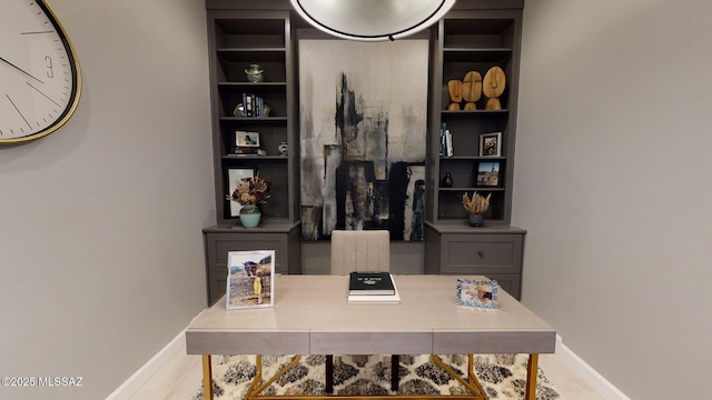 office area featuring built in shelves and baseboards